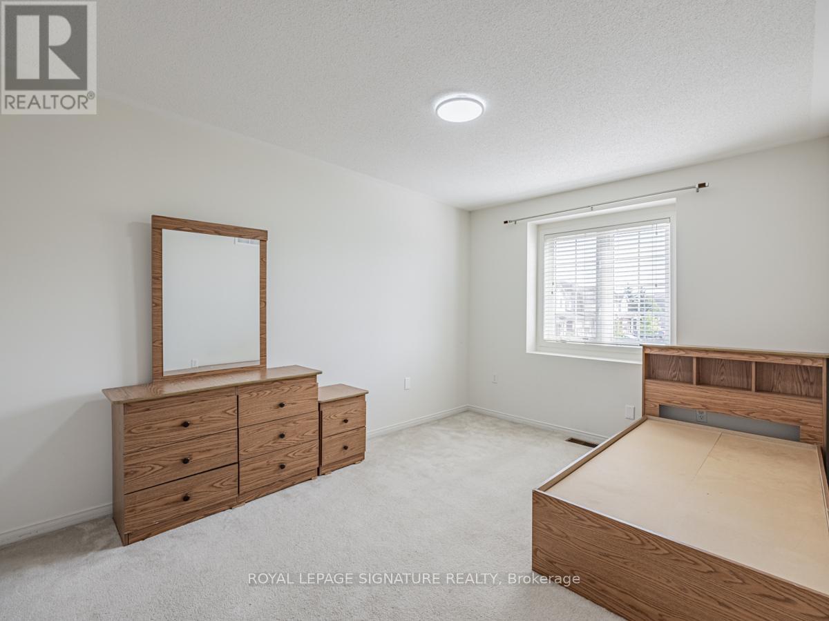 A bedroom with a bed, dresser, and mirror.