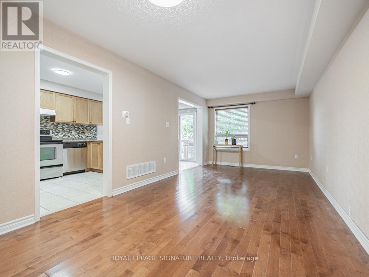 A spacious room with wooden flooring and a doorway leading to another room.