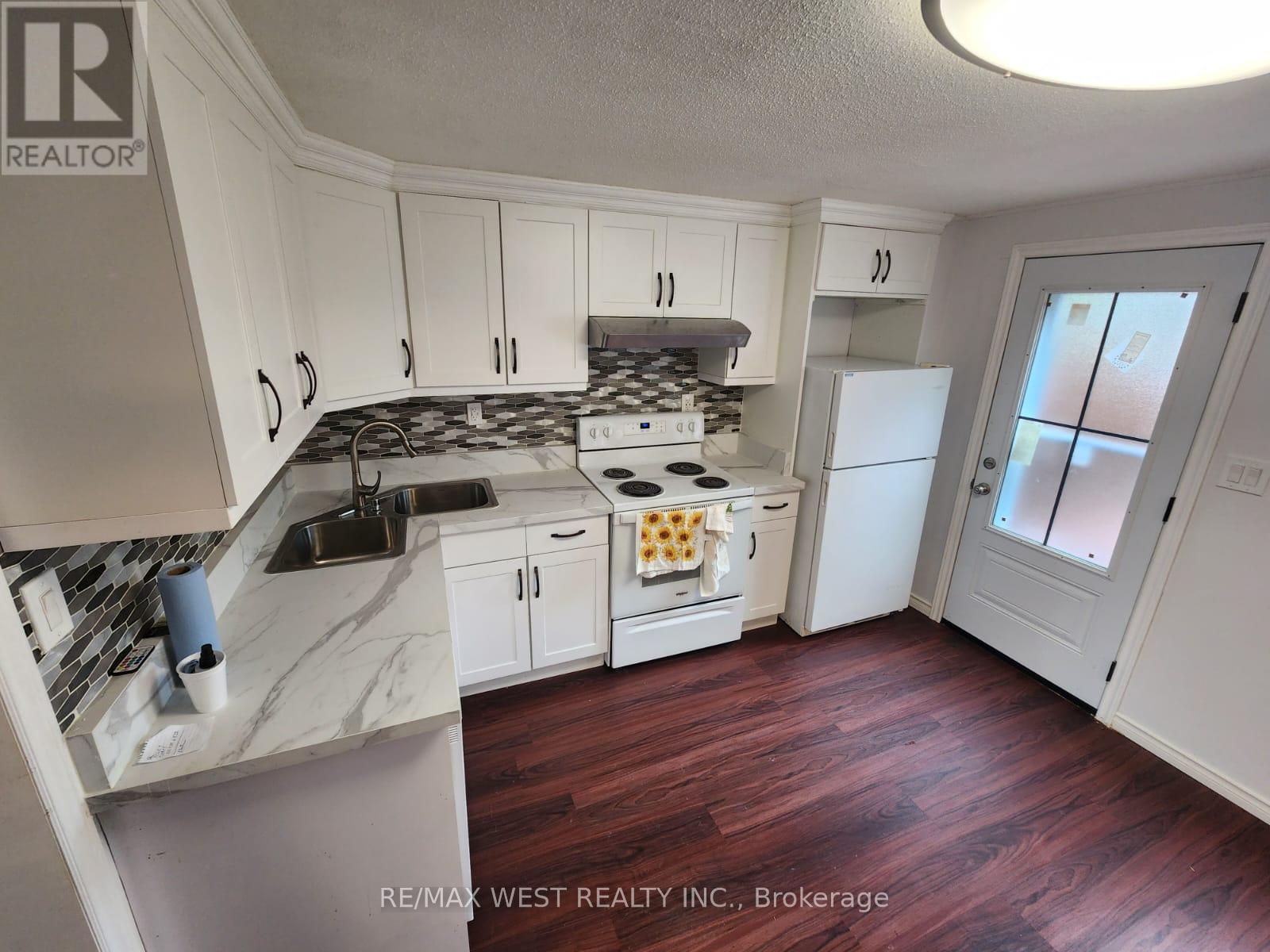 A kitchen with white cabinets and a marble countertop.