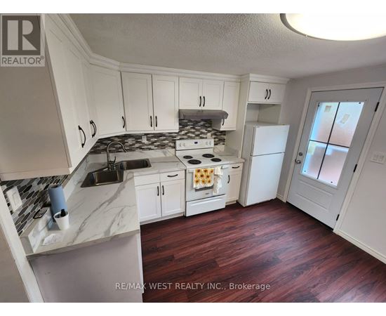 A kitchen with white cabinets and a marble countertop.