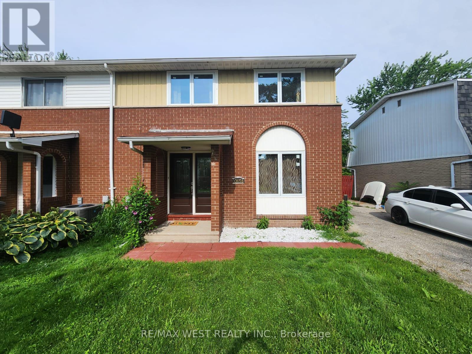 A house with a red brick facade and a white door is for sale.