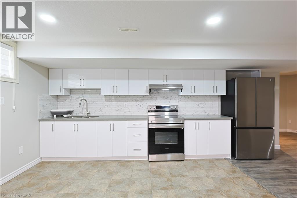 A kitchen with white cabinets and a marble backsplash.