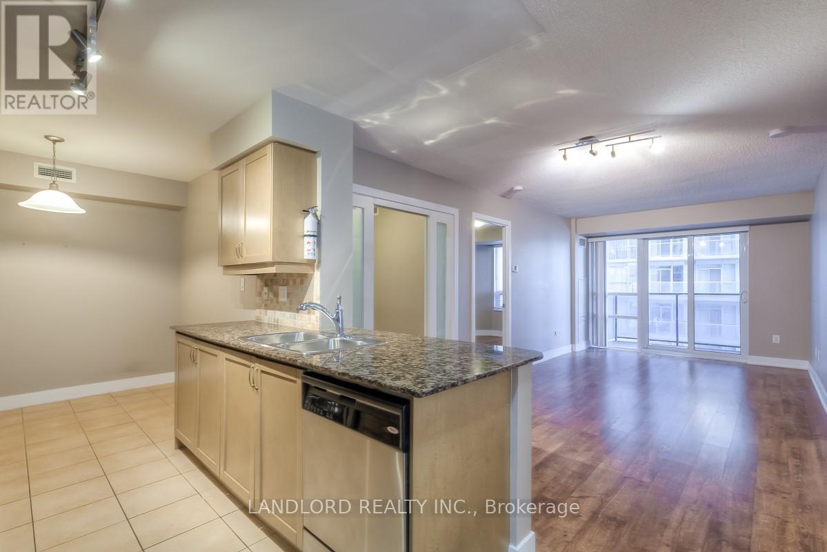 A kitchen with a granite countertop and wooden flooring.