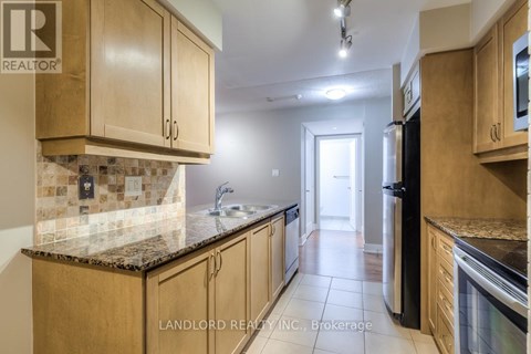 A kitchen with wooden cabinets and a black refrigerator.