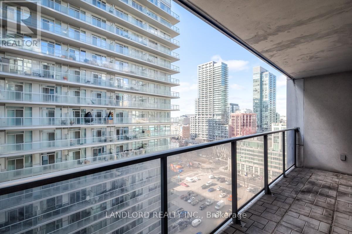 A balcony with a view of a cityscape and a building with the words "LANDLORD REALTY INC." on it.