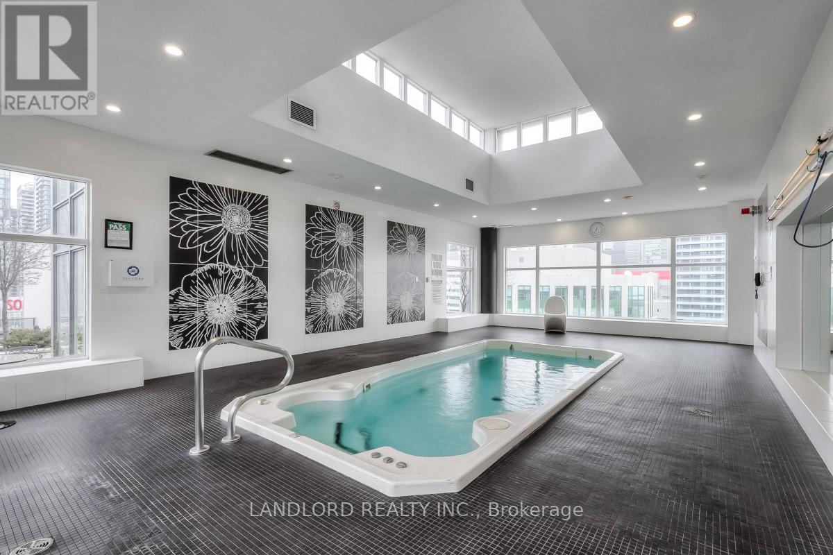 A large indoor swimming pool in a spacious room with a skylight.