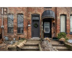 A brick house with a black door and a wreath on it.