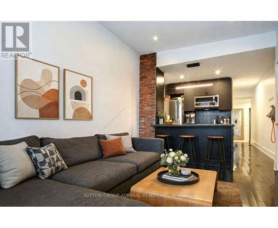 A living room with a grey couch and a coffee table with flowers on it.