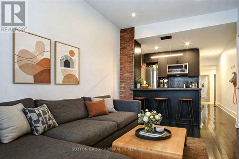 A living room with a grey couch and a coffee table with flowers on it.