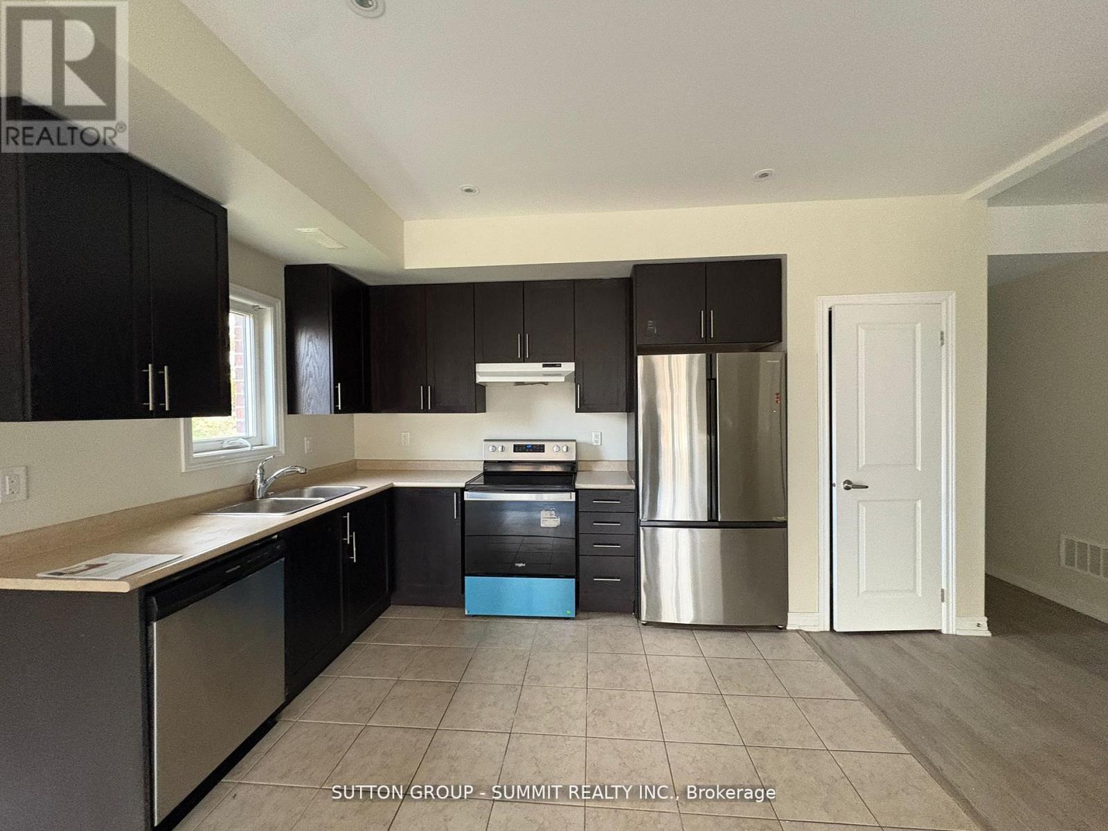 A kitchen with black cabinets and stainless steel appliances.
