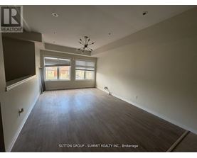 A large empty room with a ceiling fan and a window with blinds.