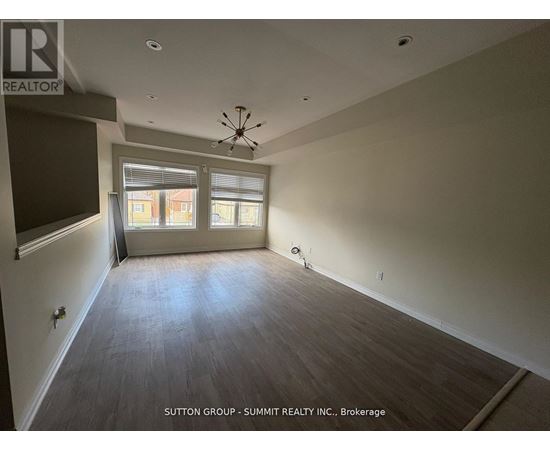 A large empty room with a ceiling fan and a window with blinds.