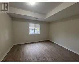 A room with wooden flooring and a window with blinds.