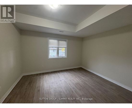 A room with wooden flooring and a window with blinds.