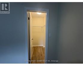 A doorway leading to a bedroom with a white door and a light on.