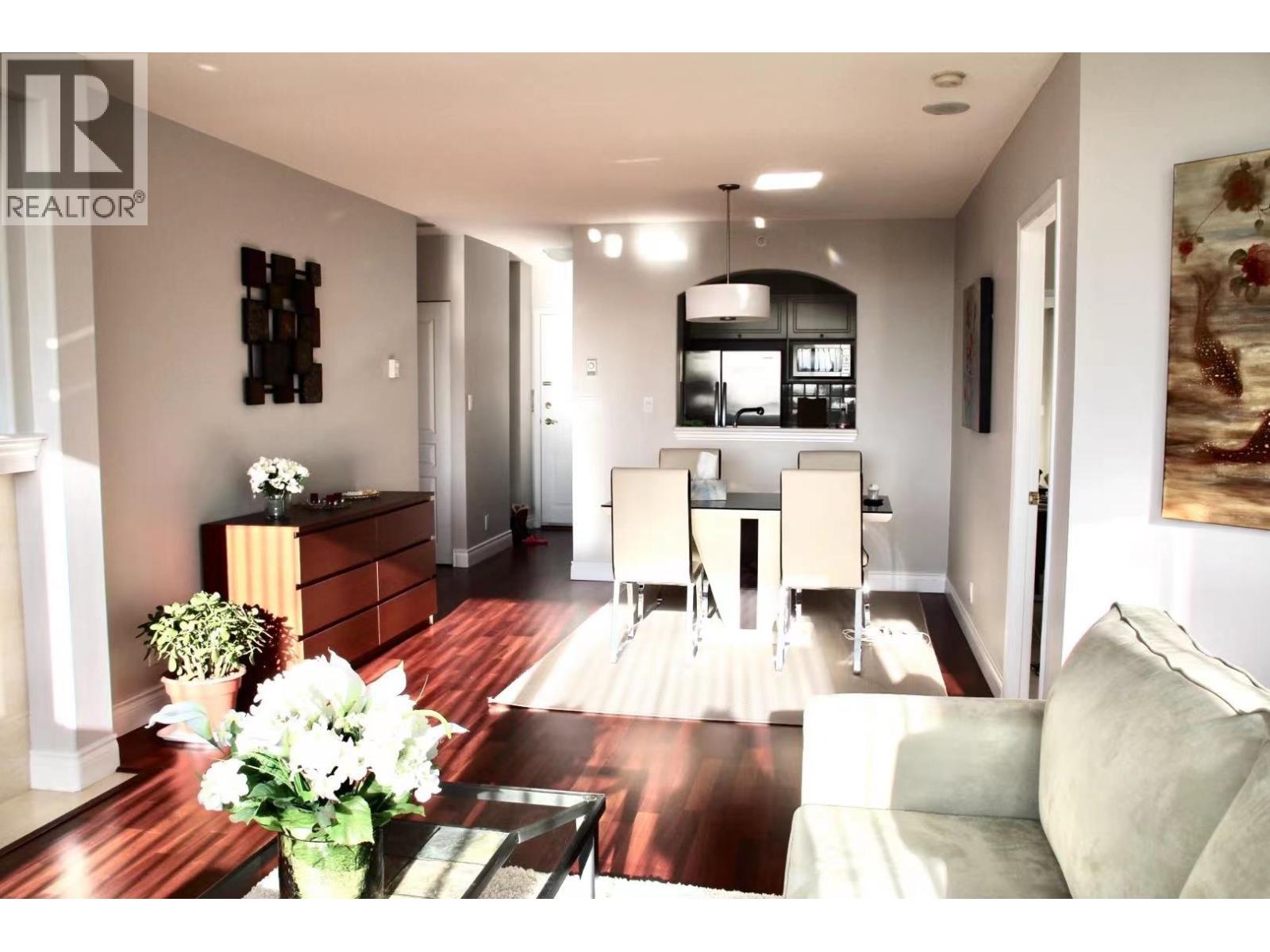 A modern living room with a wooden floor and a large painting on the wall.