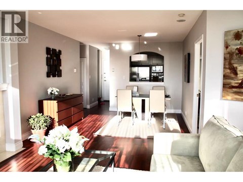 A modern living room with a wooden floor and a large painting on the wall.