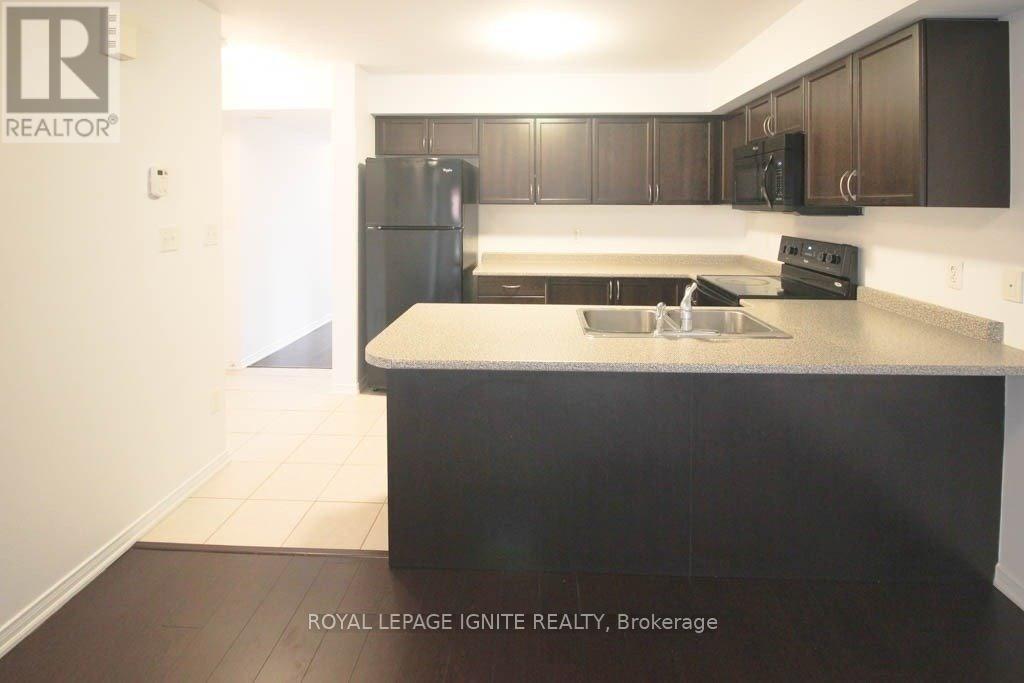 A kitchen with a sink and a refrigerator.