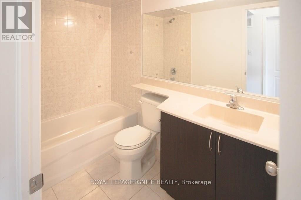 A white toilet sits in a bathroom next to a sink.