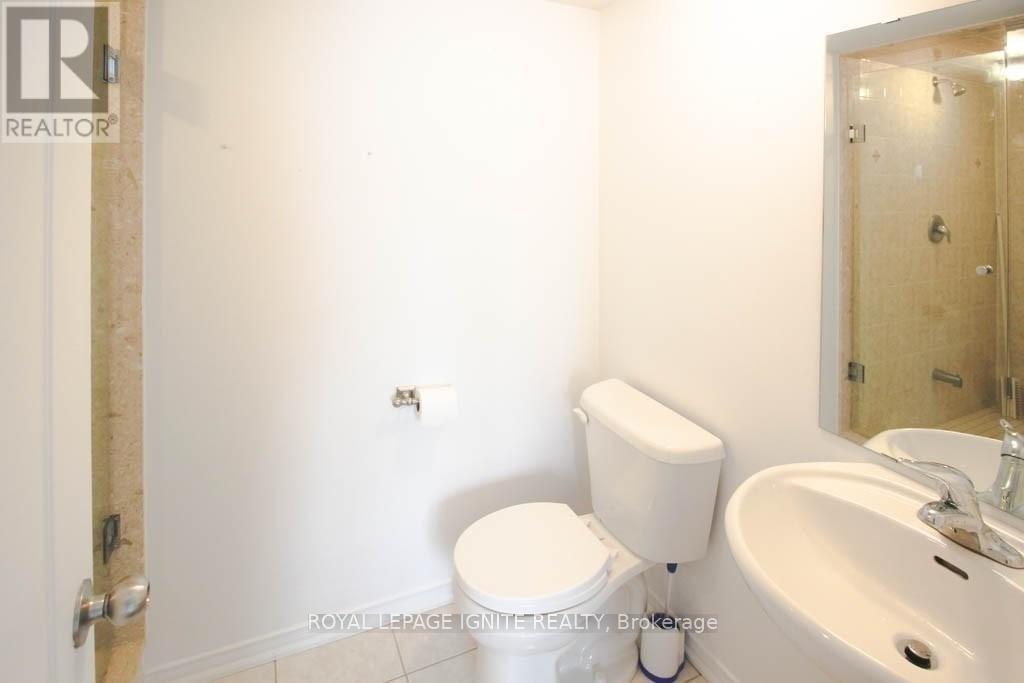 A white toilet sits next to a sink in a small bathroom.
