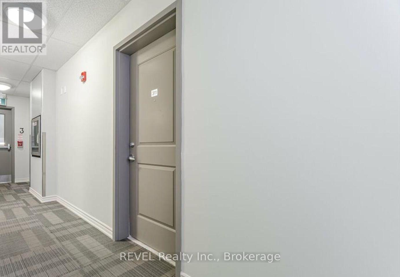 A hallway with a brokerage sign on the wall.