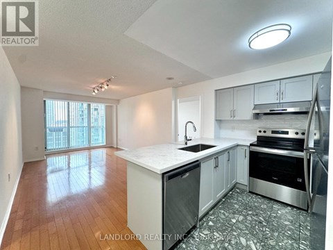 A kitchen with white cabinets and a wooden floor.