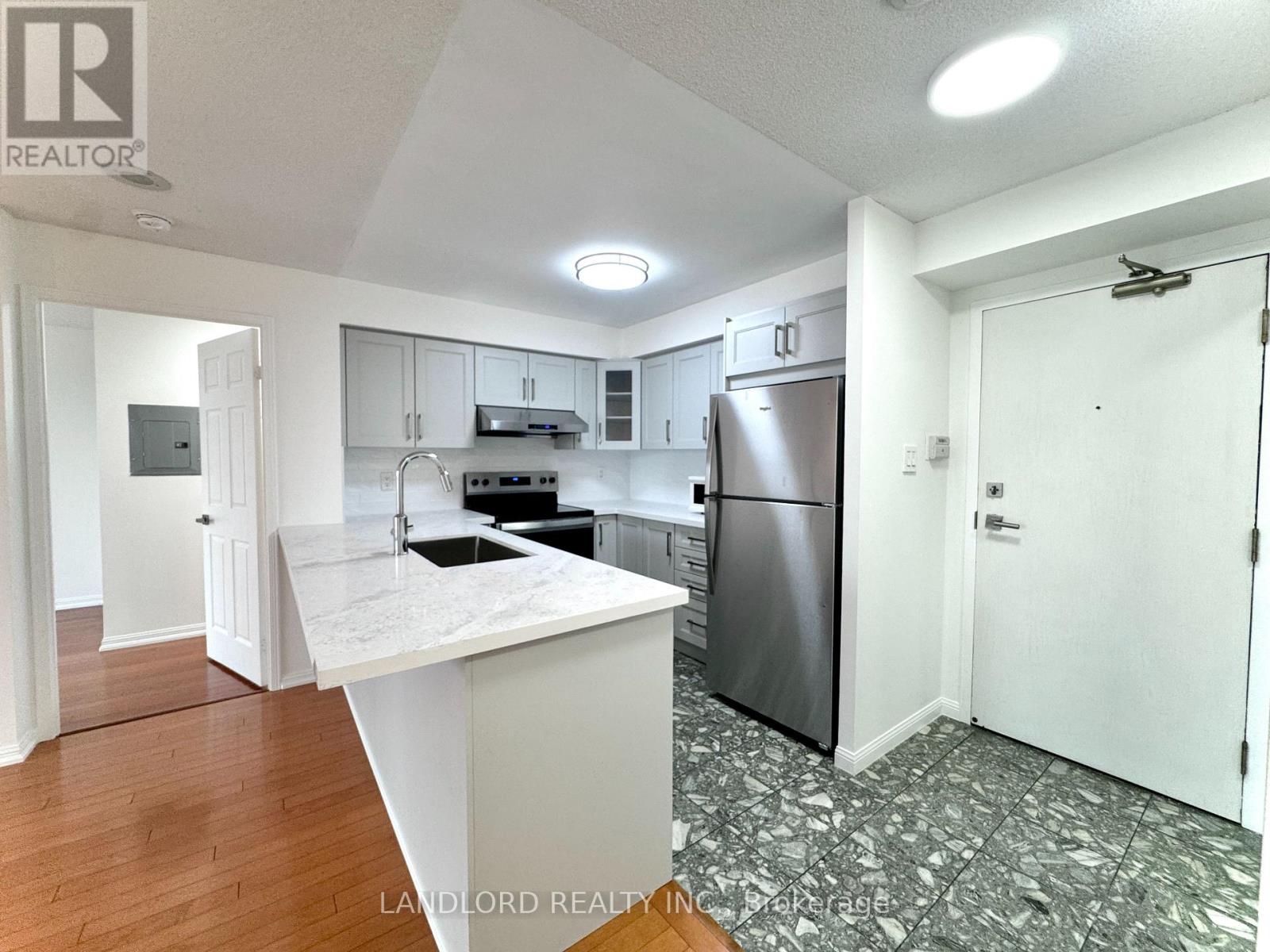 A kitchen with a white countertop and stainless steel appliances.