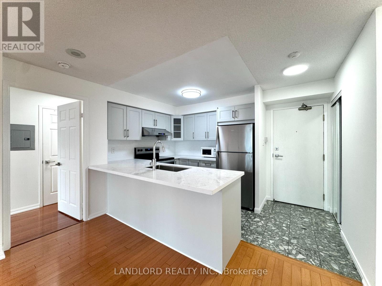 A kitchen with white cabinets and a white island.