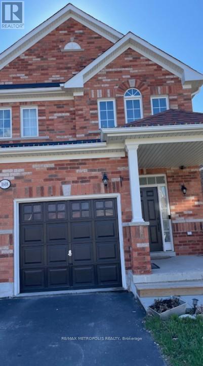 A brick house with a black garage door in front.