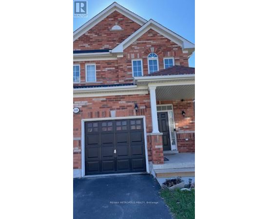A brick house with a black garage door in front.
