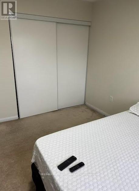 A bedroom with a bed and a closet.