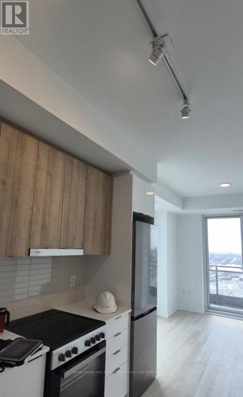 A modern kitchen with a stove top oven and a refrigerator.