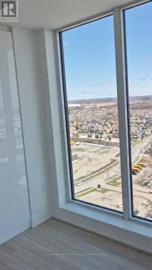 A view from a high-rise window looking out at a parking lot and buildings.