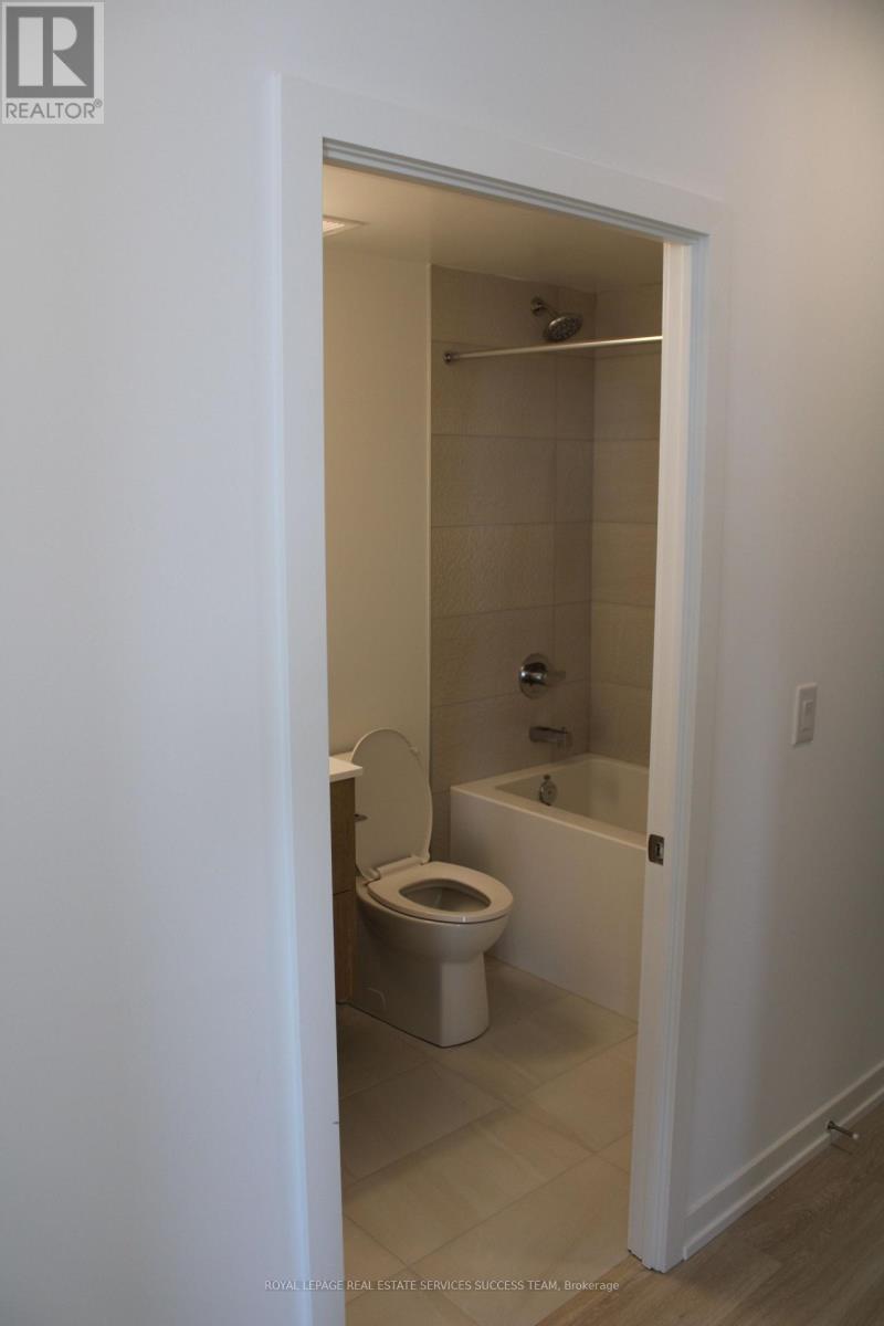 A white bathroom with a toilet, sink, and bathtub.
