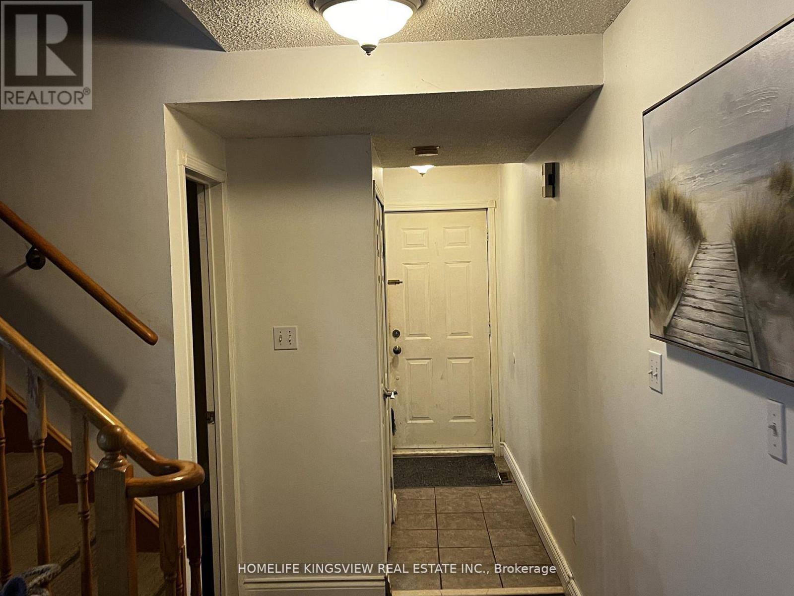 A hallway with a door and a painting on the wall.