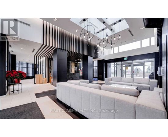 A modern living room with a large sofa and a glass wall.