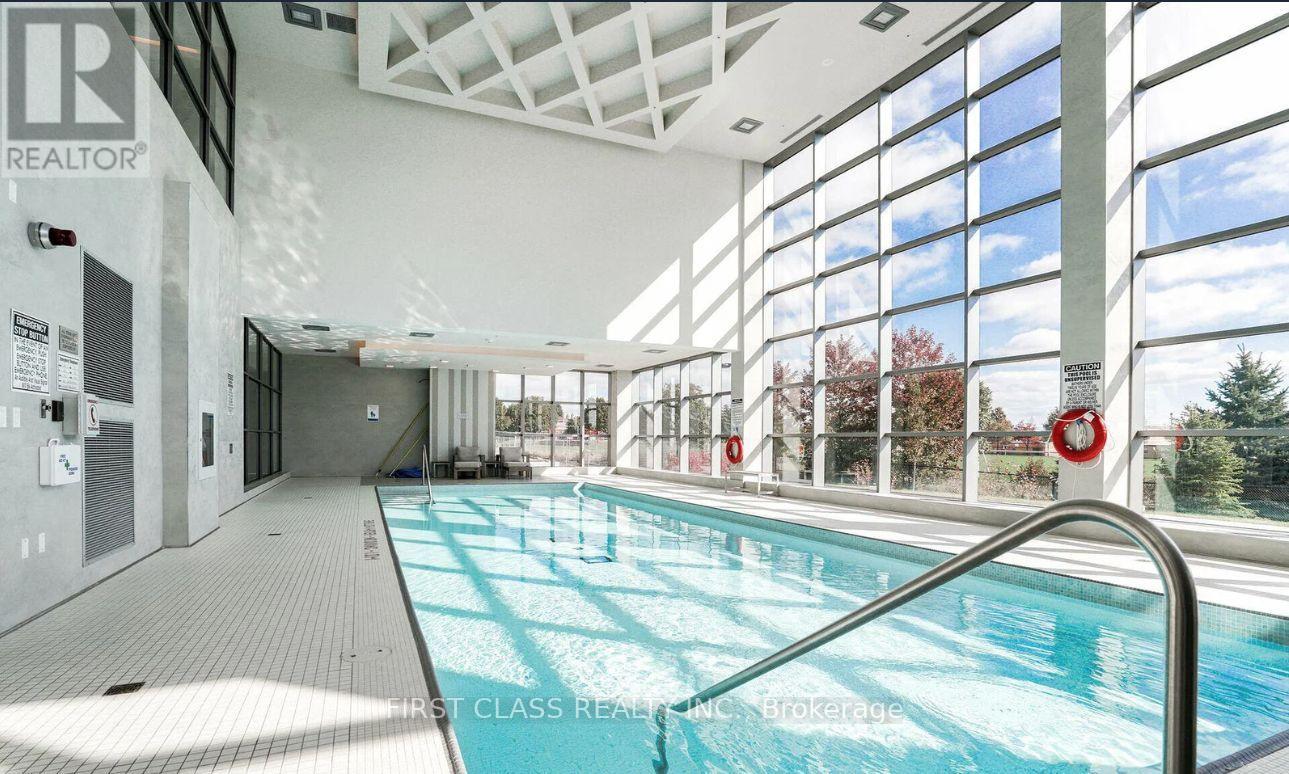 A large indoor swimming pool with a glass wall on one side.