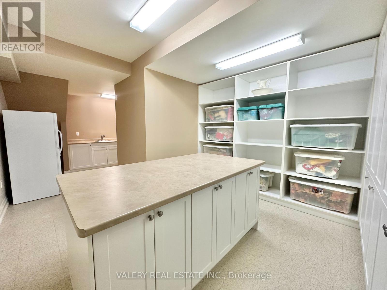 A kitchen with a white refrigerator and cabinets.