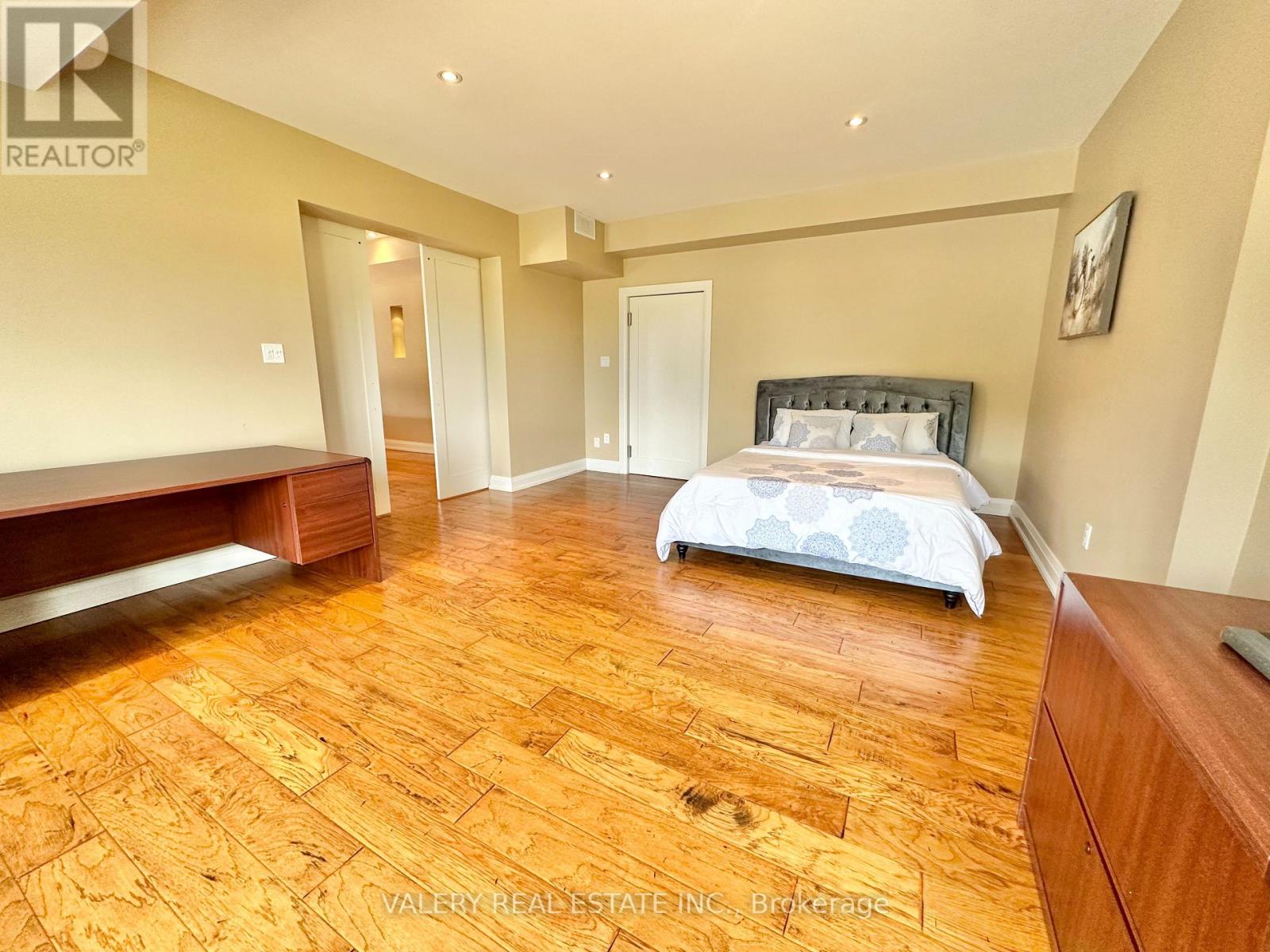 A bedroom with a bed, dresser, and mirror.
