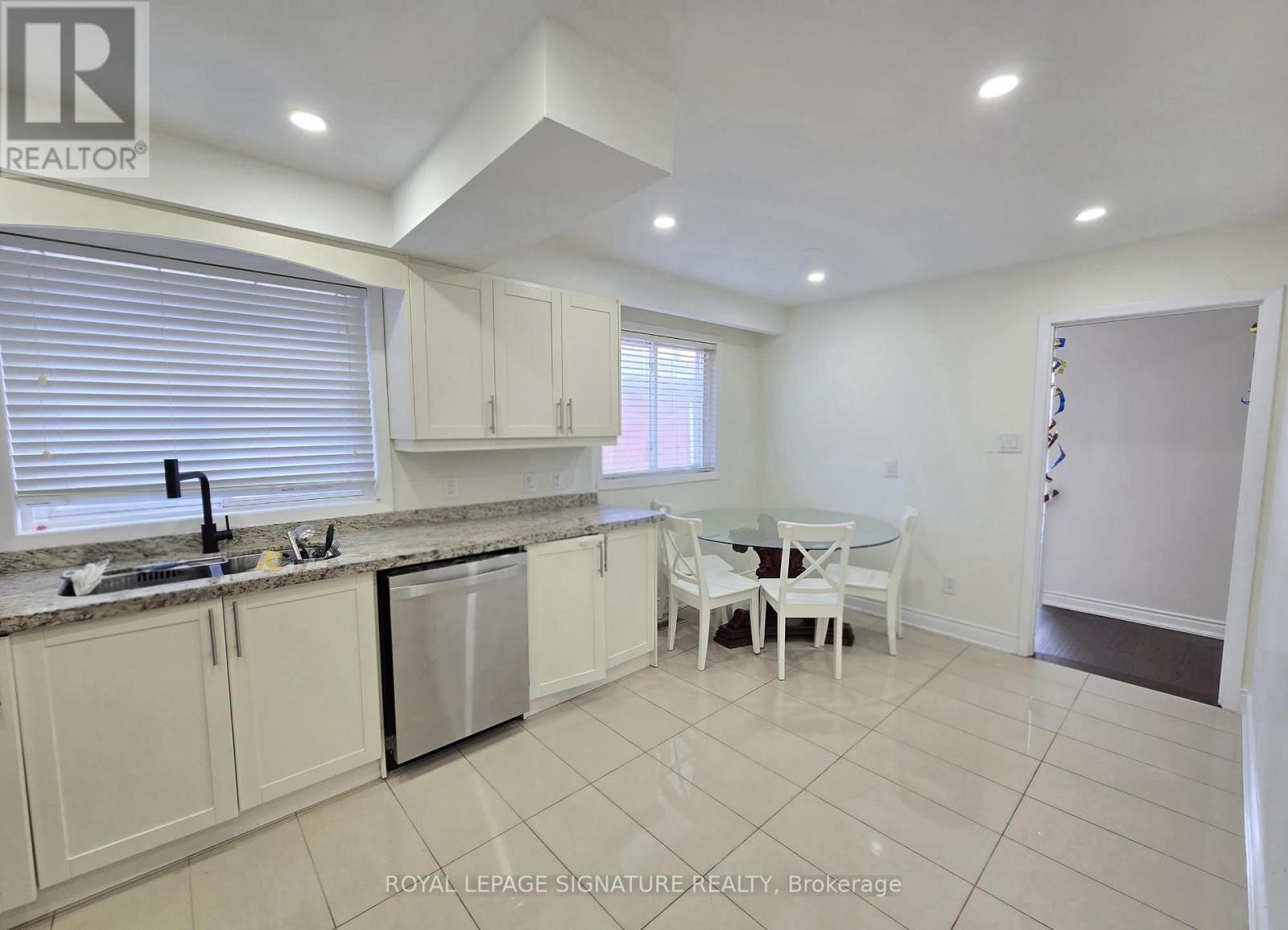 A kitchen with white cabinets and a dining table.