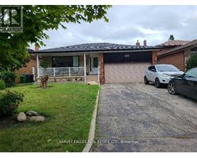 A house with a garage and a car parked in front.