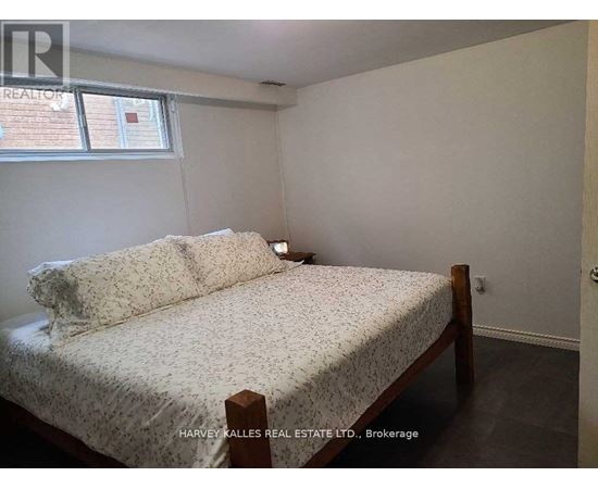 A bedroom with a bed, nightstand, and window.