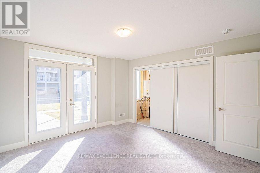A spacious room with white walls and carpeted floor.