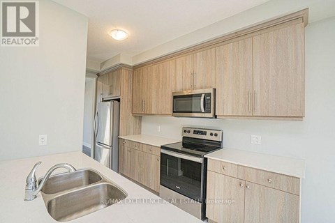 A kitchen with wooden cabinets and stainless steel appliances.