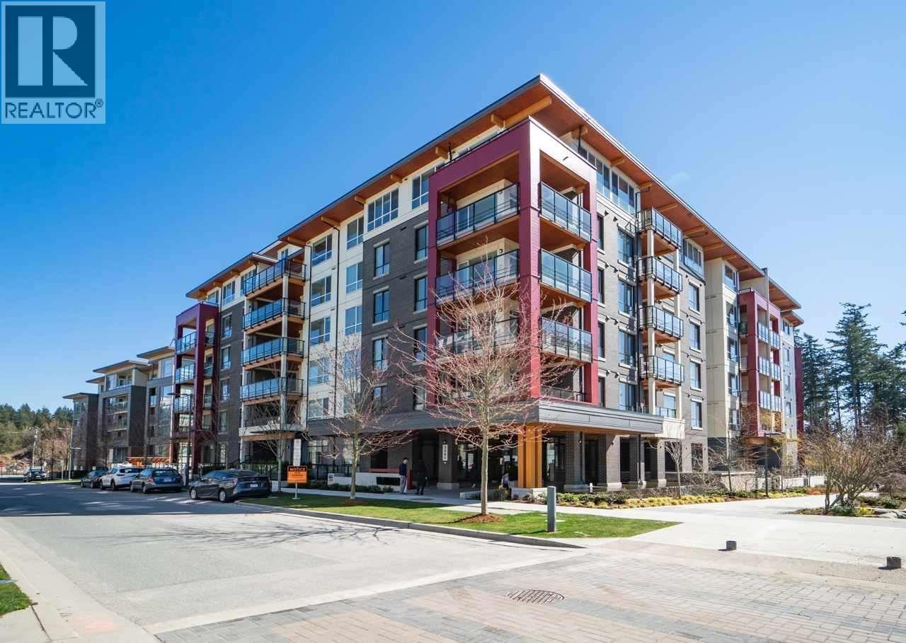 A large, modern apartment building with a clear blue sky above.