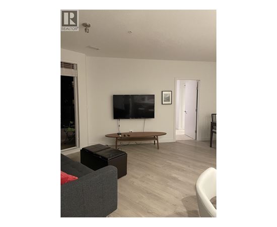 A living room with a grey couch and a wooden coffee table.