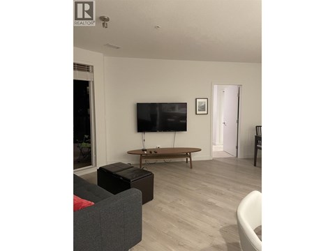 A living room with a grey couch and a wooden coffee table.