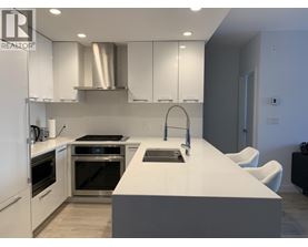 A modern kitchen with white cabinets and stainless steel appliances.