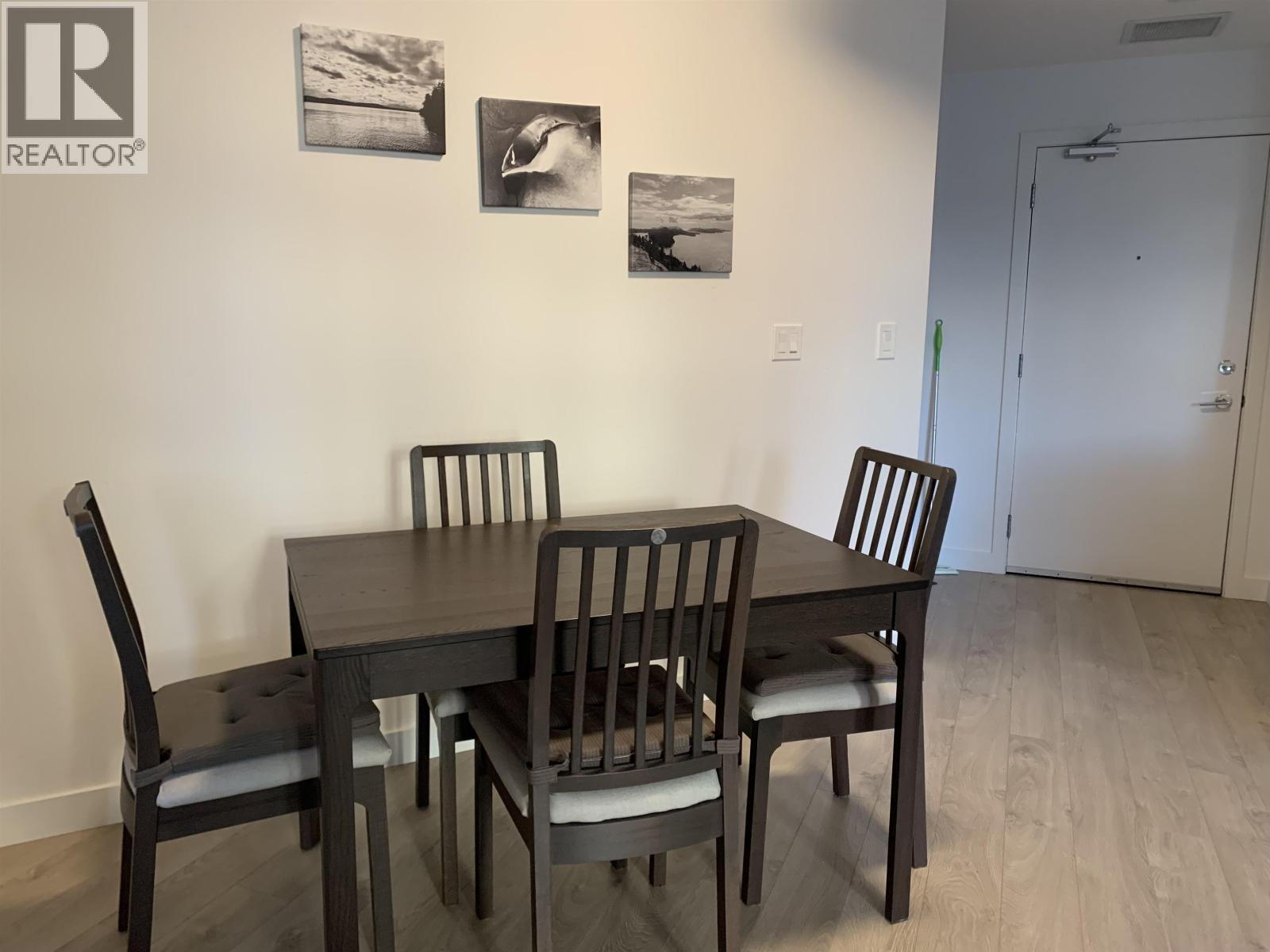 A dining room with a table and chairs.