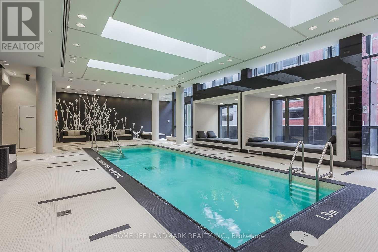 A swimming pool inside a building with a logo on the wall.